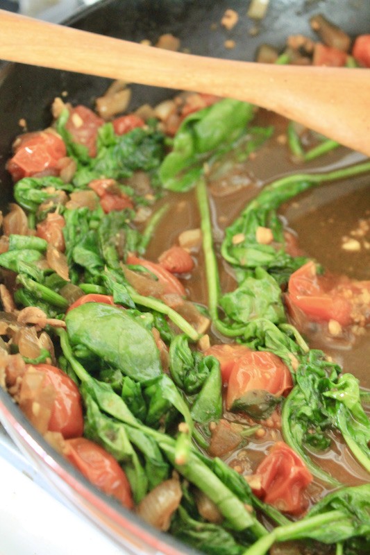stir simmered cherry tomatoes and spinach together into the sauce to wilt spinach