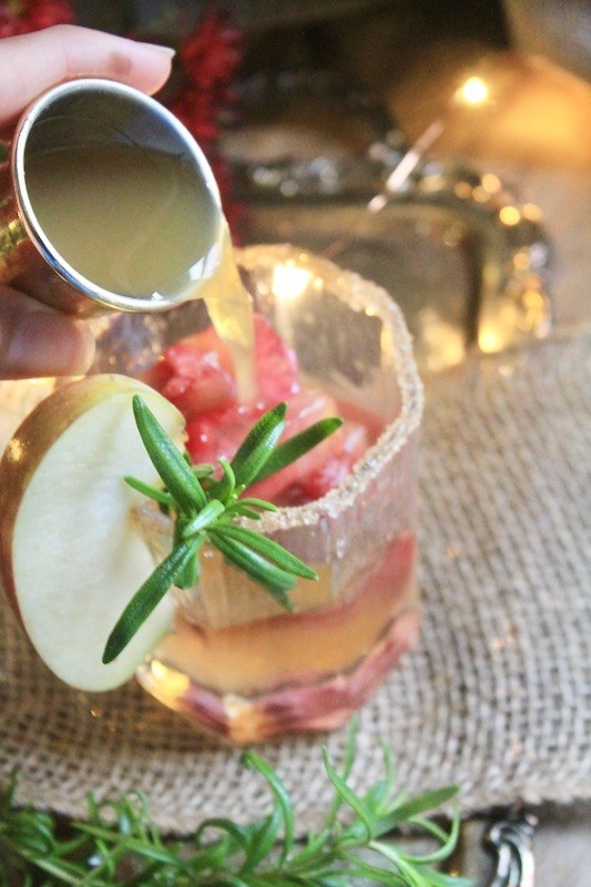 splash sparkling water into your sparkling apple fizz Christmas cocktail and stir