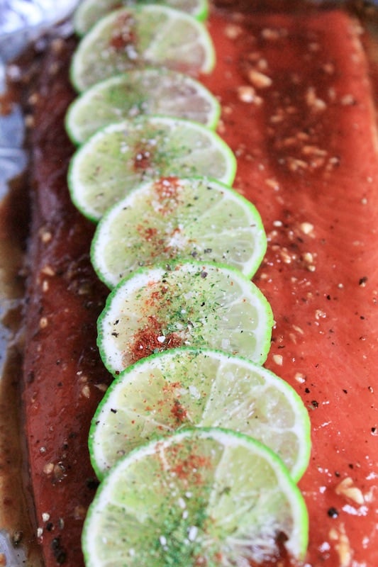 top oven baked fish with fresh lime slices and smoky paprika