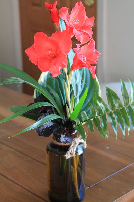 modern tropical flower arrangements in vintage bottles