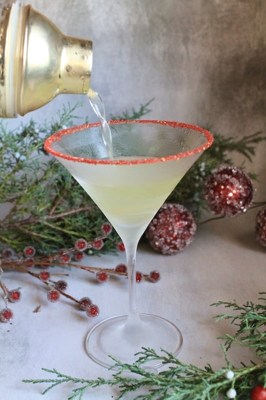 strain mixture into a martini glass with gold and red sanding sugars