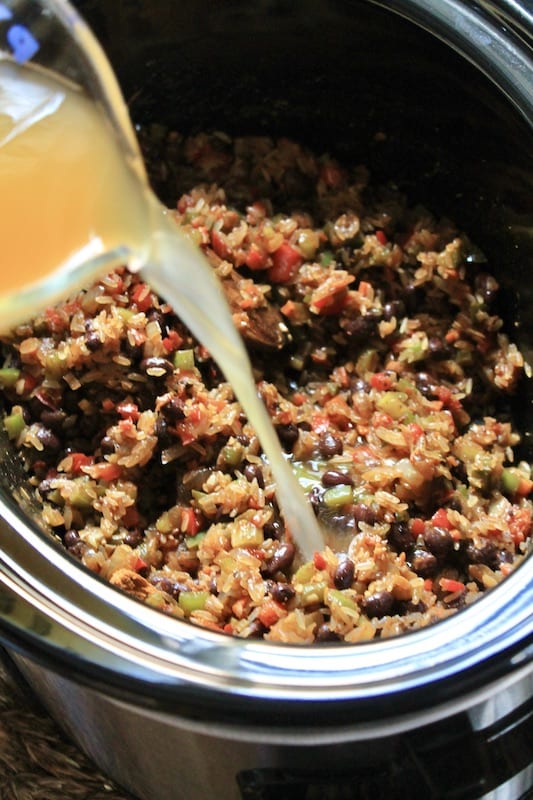 add chicken stock to slow cooker to make easy jambalaya with sausage