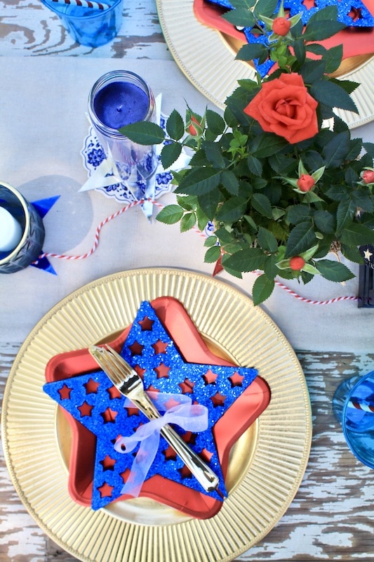 use gold chargers to mark place settings with festive 4th of july paper plates