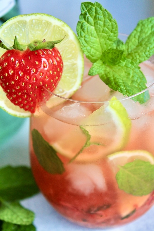garnish with fresh mint and lime and strawberries and serve cold