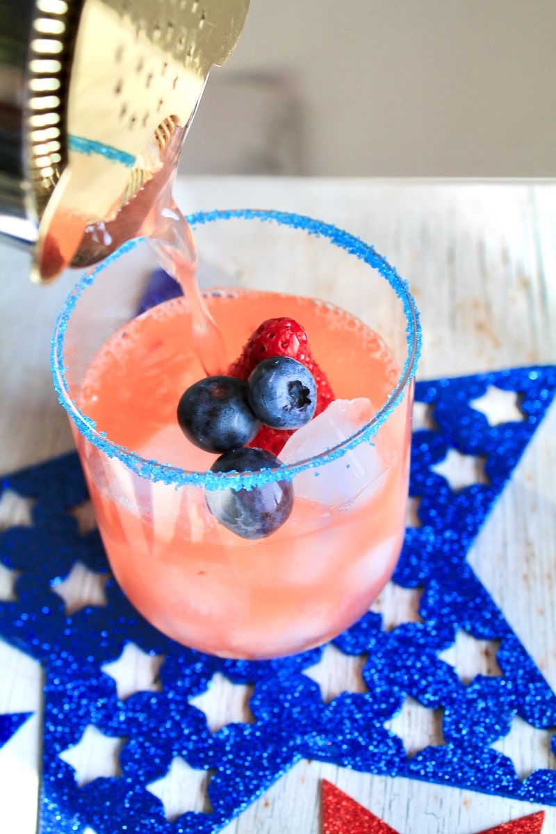 combine crushed strawberry vodka and lemonade in a cocktail shaker over ice and strain over fresh ice