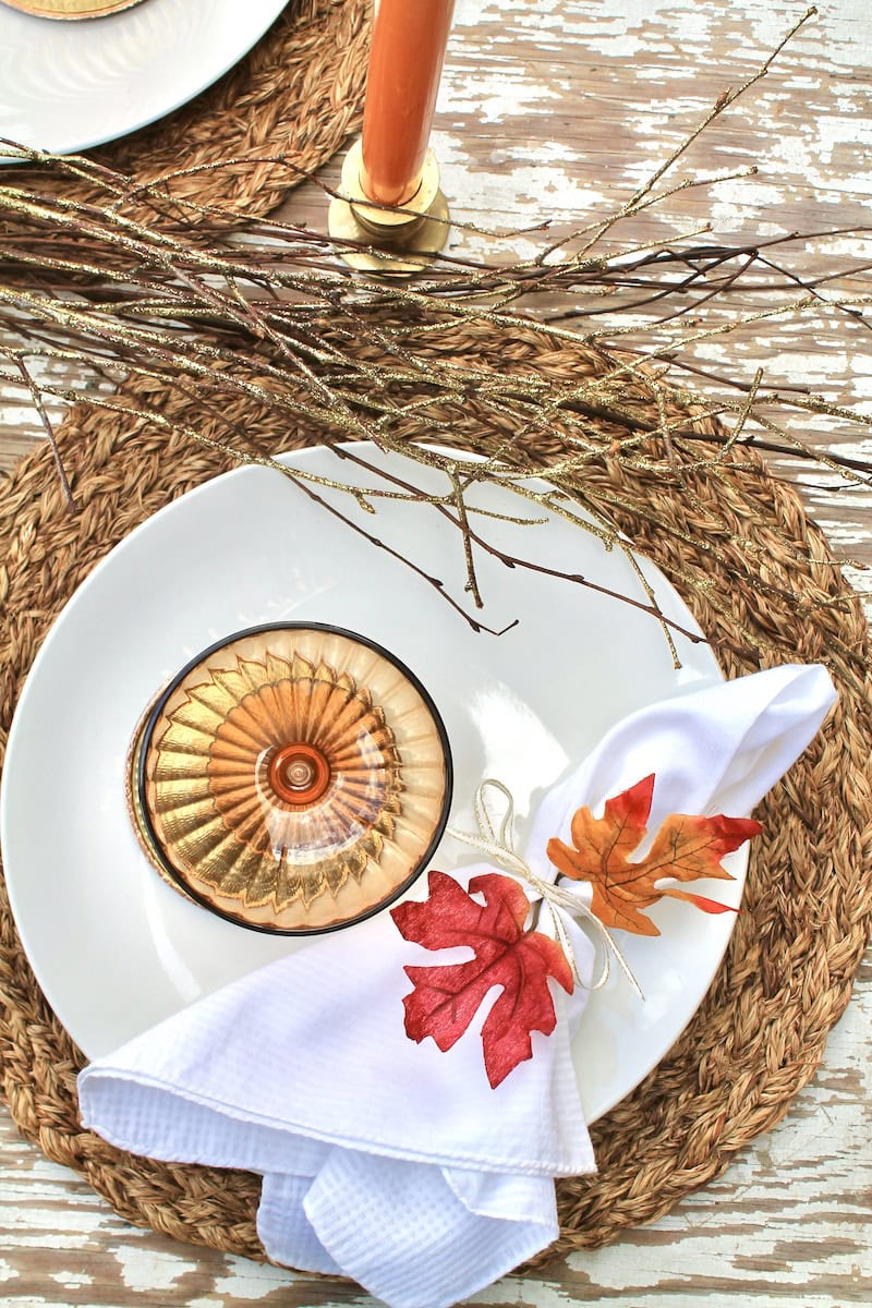 natural thanksgiving table with branches maple leaves and candles