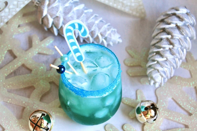 blue drink for christmas - add bourbon pineapple juice and simple syrup plus blue liqueur then shake and dust with gold glitter